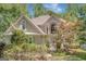 Elegant home exterior featuring lush landscaping, mature trees, and a stately facade with a manicured lawn at 606 Wingspread, Peachtree City, GA 30269