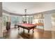 Game room featuring a pool table, hardwood floors, views of the backyard, and adjacent kitchenette at 606 Wingspread, Peachtree City, GA 30269