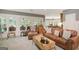 Spacious living room with a comfortable leather sofa, accent chair, and an attached recreational room with a pool table at 606 Wingspread, Peachtree City, GA 30269
