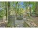 Beautiful outdoor stone patio with cozy fire pit and stone walls, surrounded by lush greenery and mature trees at 606 Wingspread, Peachtree City, GA 30269