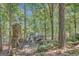 Charming outdoor stone patio with an inviting stone fireplace and beautiful views of a lush, tree-filled landscape at 606 Wingspread, Peachtree City, GA 30269