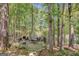 Scenic outdoor stone patio featuring a stone fireplace, dining area, and views of the surrounding lush, tree-filled landscape at 606 Wingspread, Peachtree City, GA 30269