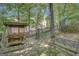 Charming outdoor area with unique swing seating, iron bench and stone patio, set amongst mature trees and lush landscaping at 606 Wingspread, Peachtree City, GA 30269