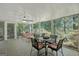 Enclosed sun room with tiled floors, ceiling fan, and furniture set on a beautiful wooded background at 606 Wingspread, Peachtree City, GA 30269