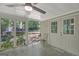 Sun room with gray tiled floors with a wooded view, a ceiling fan, and access to the outside at 606 Wingspread, Peachtree City, GA 30269