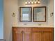 Bathroom vanity with double sinks, framed mirrors and decorative light fixture at 9187 Golfside Cir, Covington, GA 30014