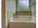 Bathroom with large soaking tub with jacuzzi jets and tile surround at 9187 Golfside Cir, Covington, GA 30014