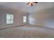 Large bedroom with neutral carpet and ample natural light streaming through two windows at 9187 Golfside Cir, Covington, GA 30014