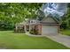 Attractive brick home featuring a well-kept lawn, mature landscaping, and a two-car attached garage at 9187 Golfside Cir, Covington, GA 30014