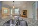 Kitchen with granite countertop, stainless sink, and view of fireplace at 9187 Golfside Cir, Covington, GA 30014
