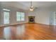 Bright living room featuring hardwood floors, a cozy stone fireplace, and ample natural light at 9187 Golfside Cir, Covington, GA 30014