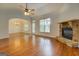Well-lit living room featuring hardwood floors, a stone fireplace, and seamless flow to the dining area at 9187 Golfside Cir, Covington, GA 30014