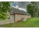 Side view of a home with a two car garage and a well-maintained lawn at 9187 Golfside Cir, Covington, GA 30014