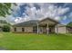 Home featuring a covered patio with ceiling fan, well-maintained lawn, and brick foundation at 9187 Golfside Cir, Covington, GA 30014