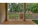 View from the back porch looking out to the backyard, with a brick outdoor fireplace and manicured lawn at 705 Lawton Bridge Sw Rd, Smyrna, GA 30082