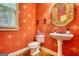 Stylish powder room with elegant gold framed mirror, pedestal sink, and eye-catching wallpaper at 705 Lawton Bridge Sw Rd, Smyrna, GA 30082