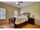 Cozy bedroom showcasing a large wood bed frame, wood floors, and bedside table at 705 Lawton Bridge Sw Rd, Smyrna, GA 30082
