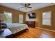 Comfortable bedroom with a ceiling fan, two windows, and hardwood floors with a neutral color palette at 705 Lawton Bridge Sw Rd, Smyrna, GA 30082