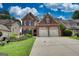 Charming two-story brick home featuring a two-car garage, and a lush green lawn at 705 Lawton Bridge Sw Rd, Smyrna, GA 30082