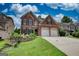 Beautiful two-story brick home with a two-car garage, a manicured lawn, and a stone garden bed at 705 Lawton Bridge Sw Rd, Smyrna, GA 30082