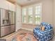 Comfortable sitting area with white shutters, a patterned chair, and a stainless steel refrigerator at 444 Silverbell Ct, Peachtree City, GA 30269