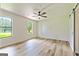 Bedroom with light wood-look flooring, windows providing natural light, and a sliding barn door at 125 Selena Ct, Fayetteville, GA 30215