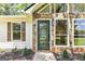 Close-up of the front entrance featuring a stone accent wall, decorative door, and manicured landscaping at 125 Selena Ct, Fayetteville, GA 30215
