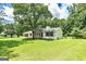 An exterior view of this charming home surrounded by a green lawn and mature trees in a quiet neighborhood at 125 Selena Ct, Fayetteville, GA 30215