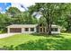 Charming single-story home featuring stone accents, a well-manicured lawn, and mature trees offering ample shade at 125 Selena Ct, Fayetteville, GA 30215