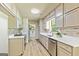 Updated kitchen boasts white cabinets, quartz countertops, stainless steel appliances, and a convenient access to the laundry room at 125 Selena Ct, Fayetteville, GA 30215