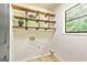 Laundry room featuring floating wood shelves, utility connections, and a window providing natural light at 125 Selena Ct, Fayetteville, GA 30215