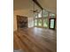 Bright living room with stone fireplace, wood floors, ceiling fan, and large windows at 125 Selena Ct, Fayetteville, GA 30215