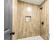 Modern shower features wood-look tile, a shower niche, and a river rock shower floor at 125 Selena Ct, Fayetteville, GA 30215