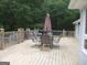View of outdoor back deck with a dining table set and wooded background at 1455 River Cove Rd, Social Circle, GA 30025