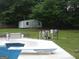 An outbuilding sits amid the backyard's lush greenery near a pool at 1455 River Cove Rd, Social Circle, GA 30025