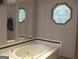 Relaxing bathroom retreat with a deep soaking tub and octagonal window at 1455 River Cove Rd, Social Circle, GA 30025