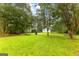 View of the backyard and shed featuring well-manicured lawn and mature trees at 201 Greensprings Dr, Palmetto, GA 30268