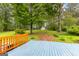 Lush backyard view from a blue wooden deck with mature trees and detached garage at 201 Greensprings Dr, Palmetto, GA 30268