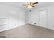 Cozy bedroom featuring neutral carpet, a ceiling fan, and three convenient closet doors at 201 Greensprings Dr, Palmetto, GA 30268