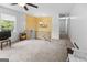 Bright living room with neutral carpet, a ceiling fan, and a staircase at 201 Greensprings Dr, Palmetto, GA 30268