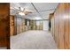 Carpeted den featuring paneled walls and a ceiling fan, offering a warm atmosphere at 201 Greensprings Dr, Palmetto, GA 30268