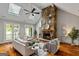 Inviting living room showcasing a stone fireplace, vaulted ceiling, skylights, and hardwood flooring at 103 Sandtrap Rdg, Peachtree City, GA 30269