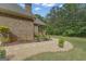 Well-maintained backyard features lush lawn, mature trees and a stone pathway leading to covered patio at 185 Platinum Ridge Pt, Fayetteville, GA 30215
