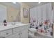 Well-lit bathroom featuring a white vanity with a sink, a toilet, and a shower with a floral patterned curtain at 185 Platinum Ridge Pt, Fayetteville, GA 30215
