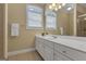 Bright bathroom with a double vanity, decorative mirror, and two arched windows that let in natural light at 185 Platinum Ridge Pt, Fayetteville, GA 30215