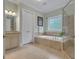 Bathroom features a soaking tub, walk-in shower with glass door, double vanity and neutral-toned tile flooring at 185 Platinum Ridge Pt, Fayetteville, GA 30215