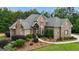 Inviting home exterior with stone and brick, complemented by green lawn and landscaping at 185 Platinum Ridge Pt, Fayetteville, GA 30215
