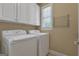 Laundry room featuring white washer and dryer, white cabinets, and natural light at 185 Platinum Ridge Pt, Fayetteville, GA 30215