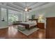 Comfortable main bedroom with a large window with seating area, stylish ceiling fan, and hardwood floors at 185 Platinum Ridge Pt, Fayetteville, GA 30215