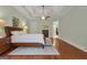 Main bedroom with stylish tray ceiling, ceiling fan, hardwood floors, and an ensuite bathroom and walk-in closet at 185 Platinum Ridge Pt, Fayetteville, GA 30215